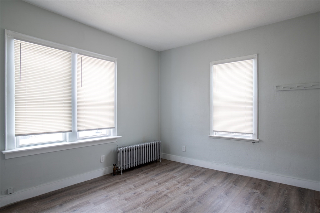 69 Winter Street Springfield, MA 01105 - Photo 20 of 36 a view of an empty room with wooden floor and a window