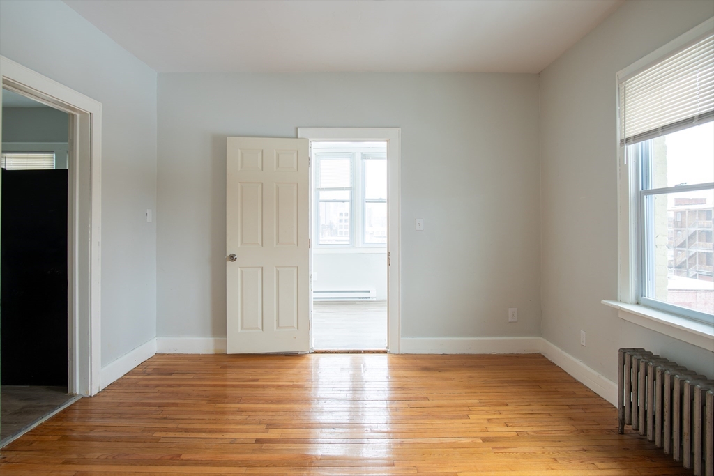 69 Winter Street Springfield, MA 01105 - Photo 25 of 36 an empty room with wooden floor and windows