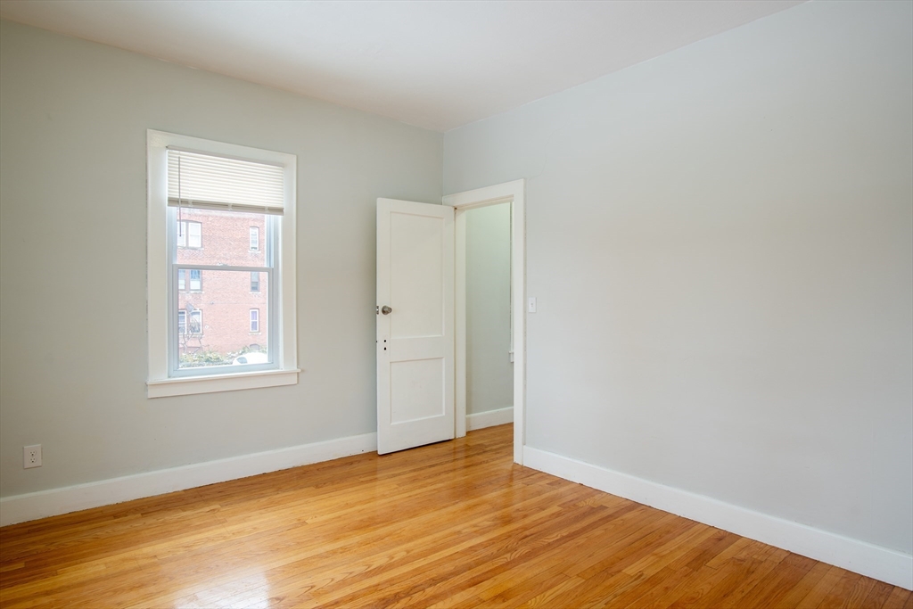 69 Winter Street Springfield, MA 01105 - Photo 31 of 36 an empty room with wooden floor and windows
