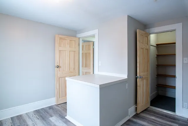 an empty room with wooden floor and closet