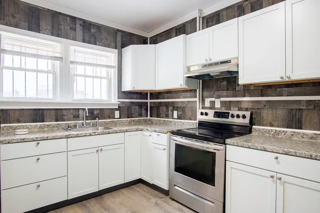 a kitchen with granite countertop white cabinets and white appliances