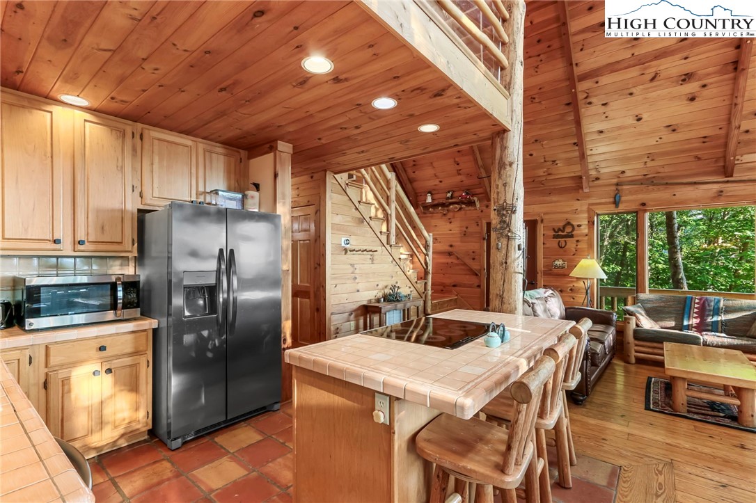 2095 Elk Ridge Road Ferguson, NC 28624 - Photo 13 of 47 a kitchen with stainless steel appliances granite countertop a refrigerator a sink a stove and white cabinets with wooden floor