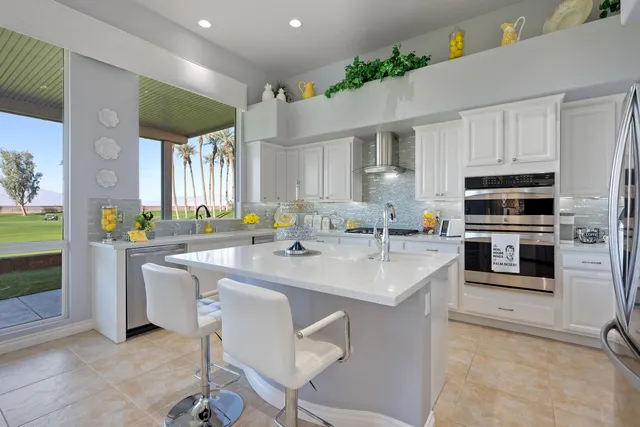a view of kitchen with stainless steel appliances a sink a counter top space and windows