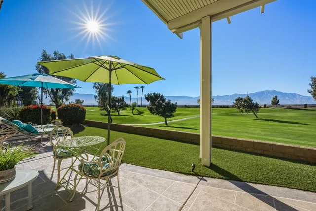a view of a patio with a table and chairs under an umbrella