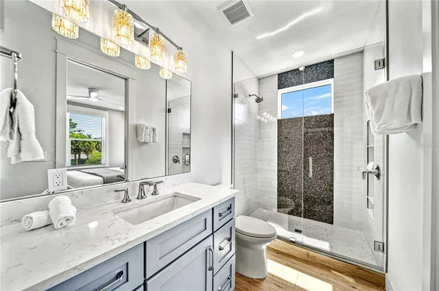 a bathroom with a sink a toilet and shower