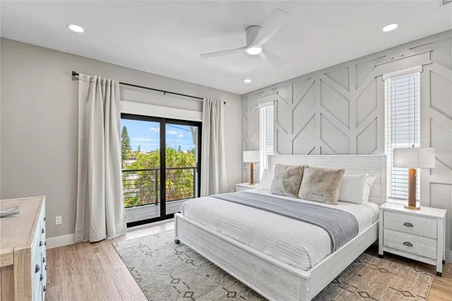 a view of hallway with wooden floor and fan