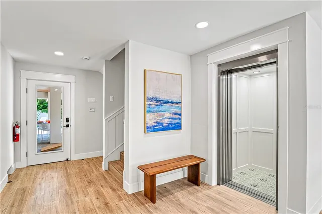 a kitchen with stainless steel appliances kitchen island granite countertop a dining table chairs and refrigerator