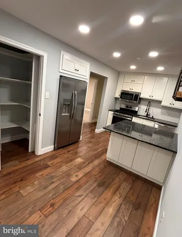 a kitchen with stainless steel appliances granite countertop a stove a sink and a refrigerator