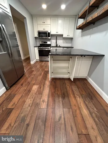 a kitchen with wooden floors and appliances