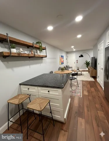 a kitchen with stainless steel appliances a table and chairs in it