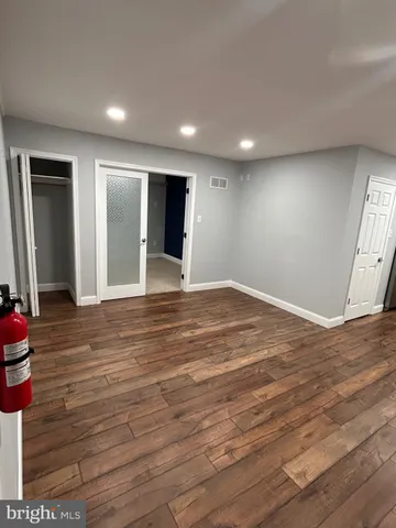 an empty room with wooden floor and closet