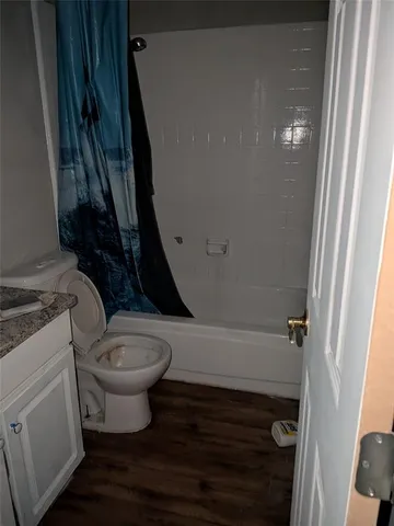 a bathroom with a granite countertop sink a toilet and bathtub