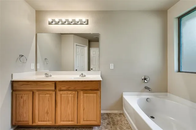 a bathroom with a tub sink and mirror