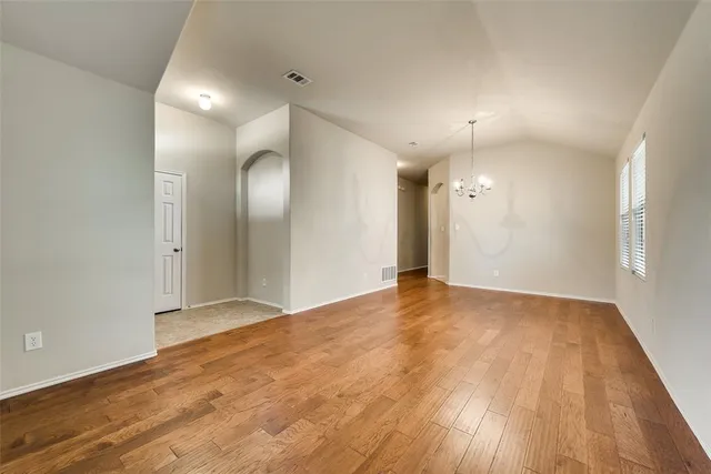 an empty room with wooden floor and mirror