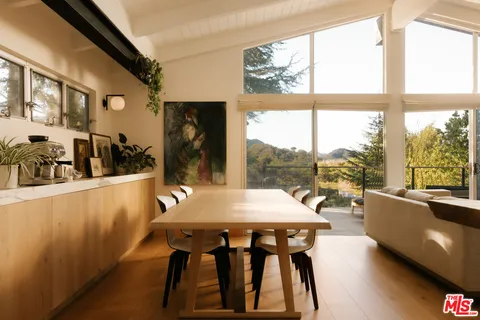 a living room with furniture tv and a floor to ceiling window