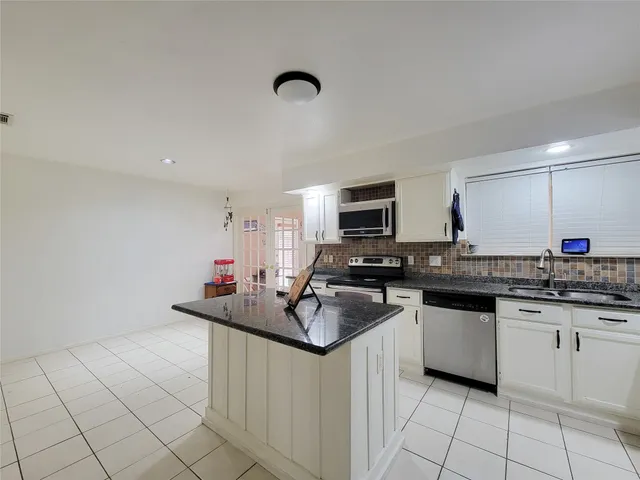 a kitchen with stainless steel appliances granite countertop a sink dishwasher stove top oven and cabinets