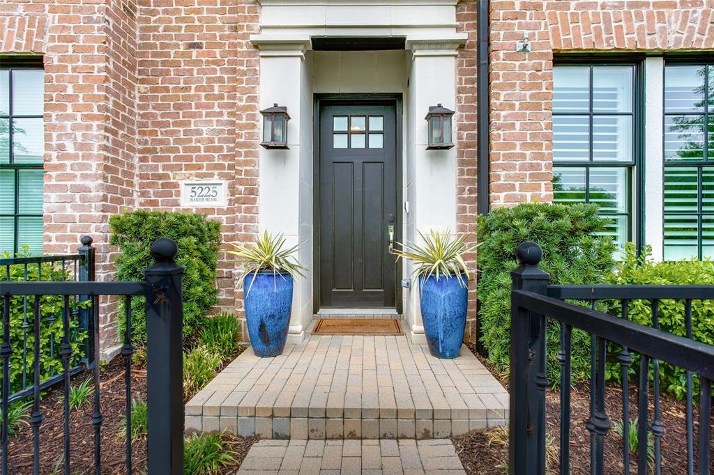 a view of a house with large windows and plants