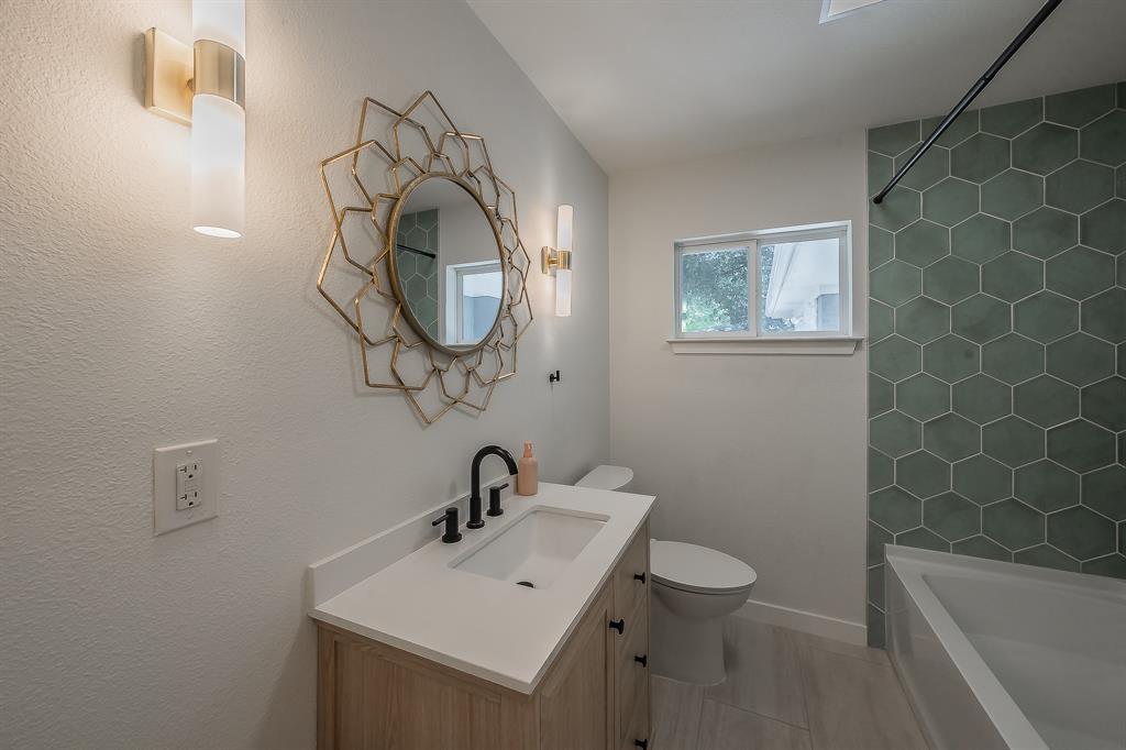 3031 Woodwind Lane Dallas, TX 75229 - Photo 18 of 29 a bathroom with a sink a toilet and a mirror