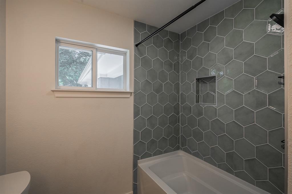 3031 Woodwind Lane Dallas, TX 75229 - Photo 19 of 29 a bath room with a toilet and a bath tub