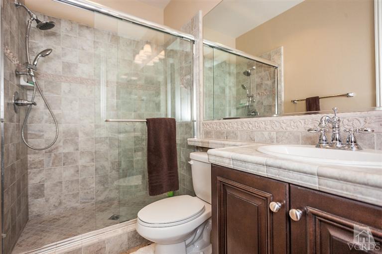 7351 Sarazen Drive Moorpark, CA 93021 - Photo 18 of 39 a bathroom with a granite countertop sink toilet and shower
