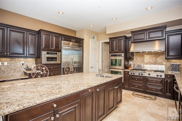 7351 Sarazen Drive Moorpark, CA 93021 - Photo 3 of 39 a kitchen with stainless steel appliances kitchen island granite countertop a sink stove and refrigerator