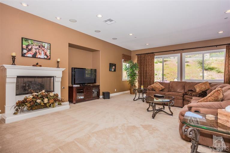 7351 Sarazen Drive Moorpark, CA 93021 - Photo 9 of 39 a living room with furniture a flat screen tv and a fireplace