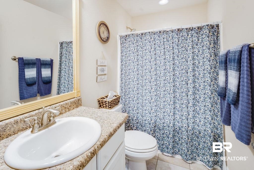 22281 Respite Lane Foley, AL 36535 - Photo 21 of 31 Bathroom with tile patterned flooring, a shower with curtain, vanity, and toilet