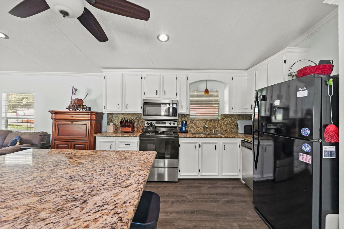 729 Lake Shore Drive Trinity, TX 75862 - Photo 15 of 38 a kitchen with stainless steel appliances kitchen island granite countertop a refrigerator stove top oven and sink