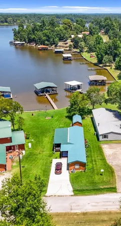 an aerial view of residential houses with outdoor space and lake view