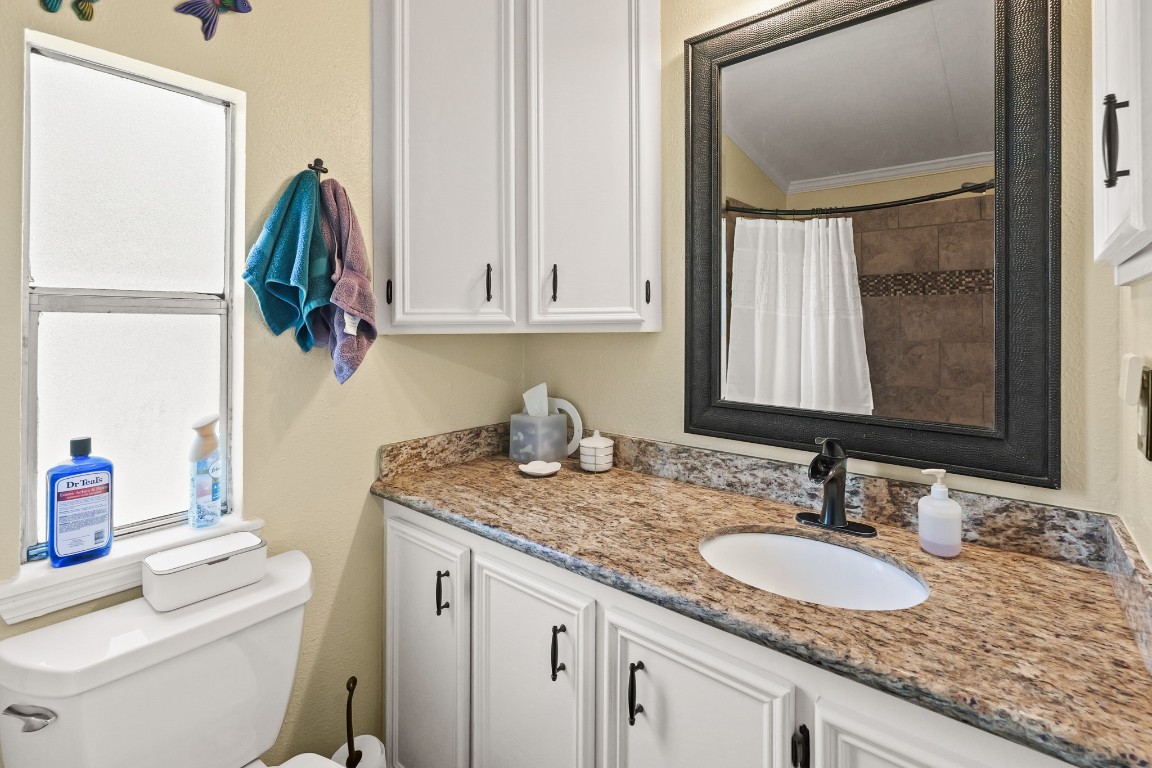 729 Lake Shore Drive Trinity, TX 75862 - Photo 23 of 38 a bathroom with a granite countertop sink and a mirror