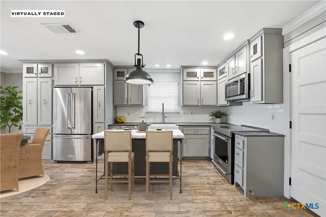 a kitchen with stainless steel appliances granite countertop a refrigerator a stove top oven a sink dishwasher and white cabinets