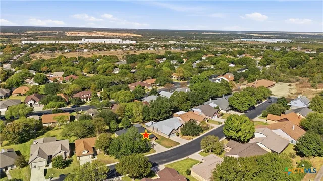 an aerial view of residential houses with outdoor space and trees