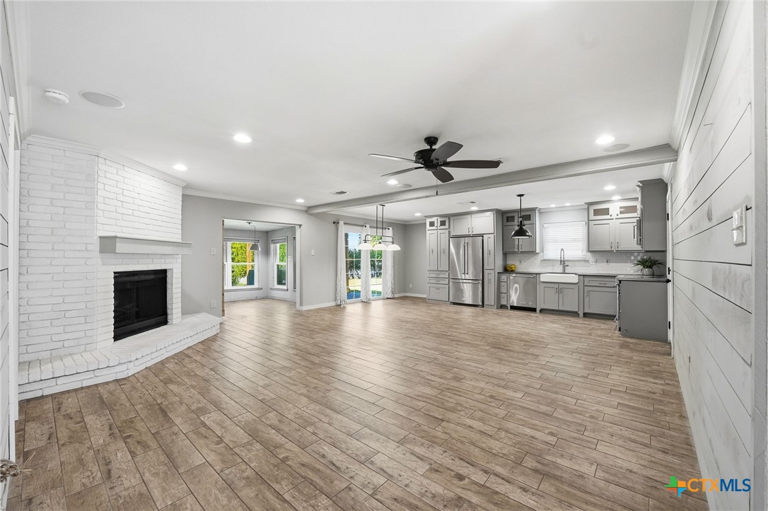 3624 Fox Run Schertz, TX 78108 - Photo 5 of 46 a view of a livingroom with a fireplace a ceiling fan and windows