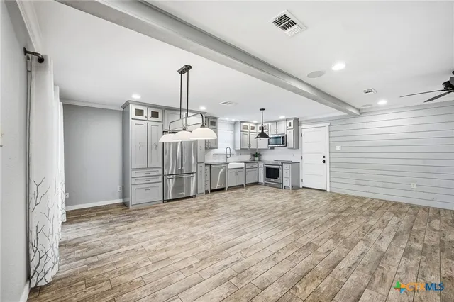a view of a kitchen with furniture and wooden floor
