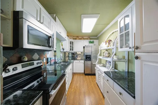 a kitchen with stainless steel appliances a stove a sink and a microwave