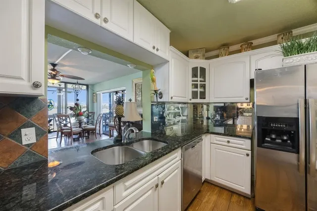 a kitchen with granite countertop a sink a counter top space appliances and cabinets