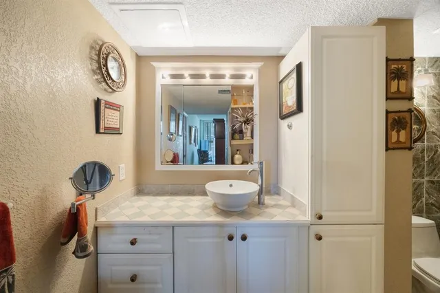 a bathroom with a granite countertop sink and a mirror