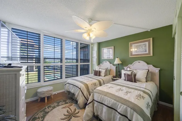 a bedroom with two beds and a large window