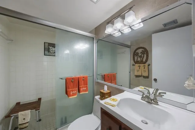 a bathroom with a sink vanity mirror and toilet