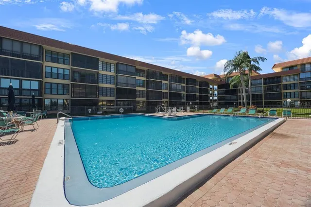 a view of a swimming pool with a chair and tables in the patio