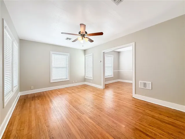 a view of a room with wooden floor and ceiling fan