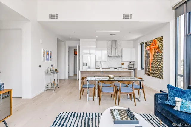 a dining room with stainless steel appliances a table and chairs