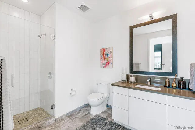 a bathroom with a granite countertop sink a toilet and a mirror