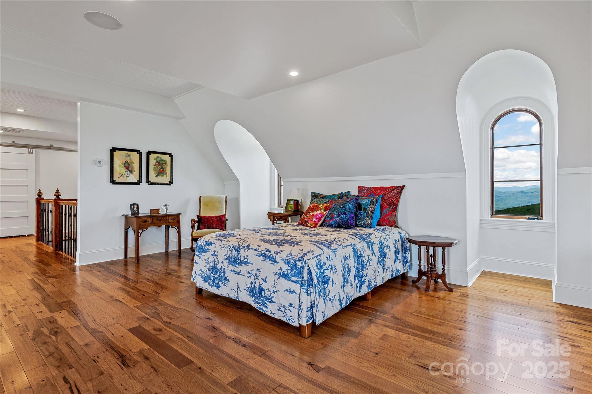 278 North Snow Ridge Drive Fairview, NC 28730 - Photo 33 of 48 a bedroom with a large bed and a wooden floor