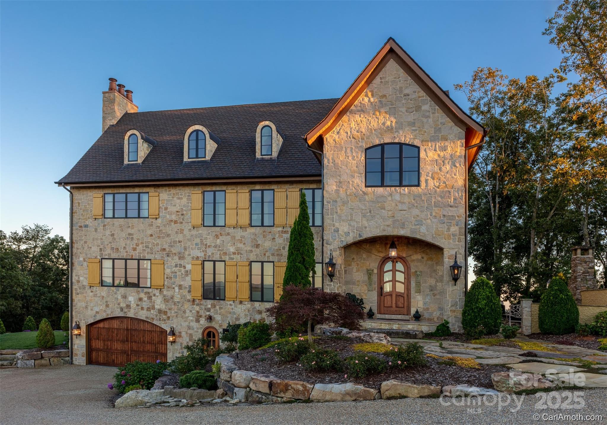 278 North Snow Ridge Drive Fairview, NC 28730 - Photo 4 of 48 a front view of a house with plants and garage