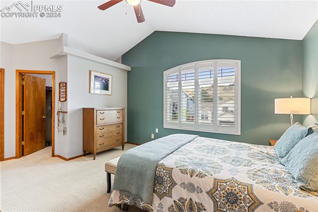 7510 Julynn Road Colorado Springs, CO 80919 - Photo 14 of 36 Primary bedroom has a large window, vaulted ceilings, and a walk-in closet