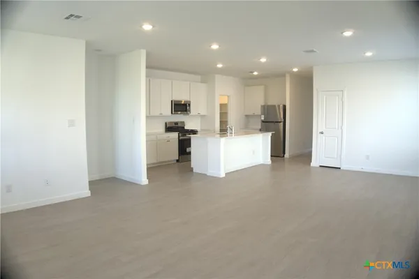 a view of a kitchen with furniture and refrigerator