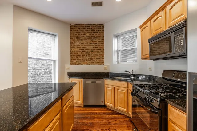 a kitchen with stainless steel appliances granite countertop a stove sink and cabinets