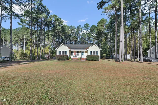 a front view of a house with a yard and trees