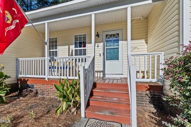 a view of a house with a small yard and wooden floor and fence